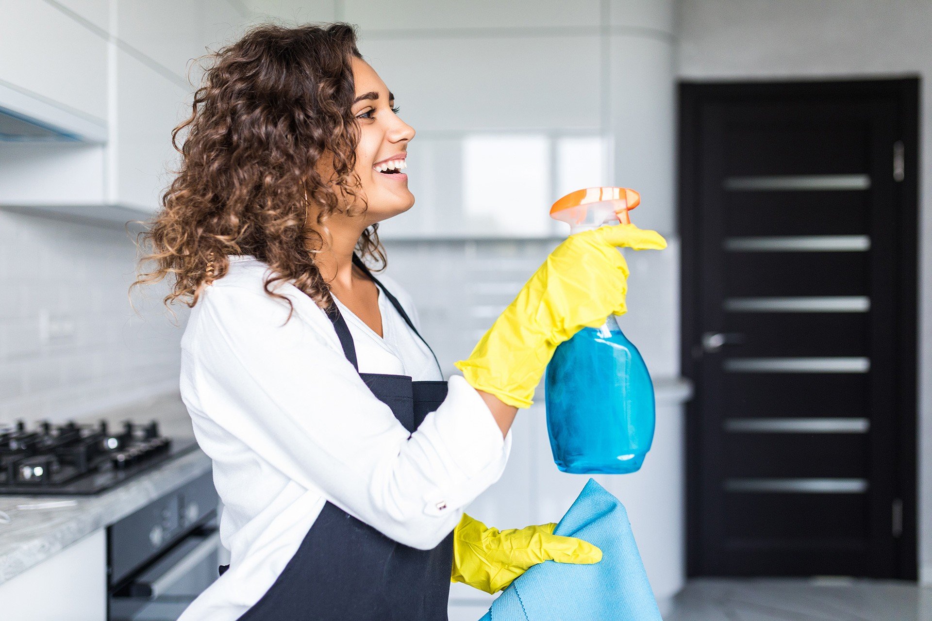 Limpiadora profesional limpiando una cocina en una viviend